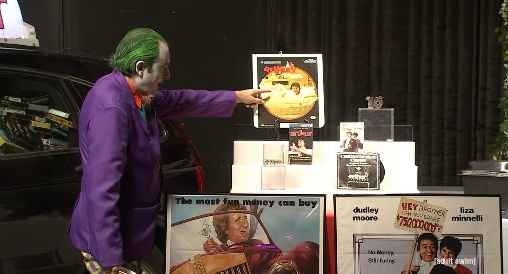 Gregg dressed as the Joker pointing out his Arthur memorabilia